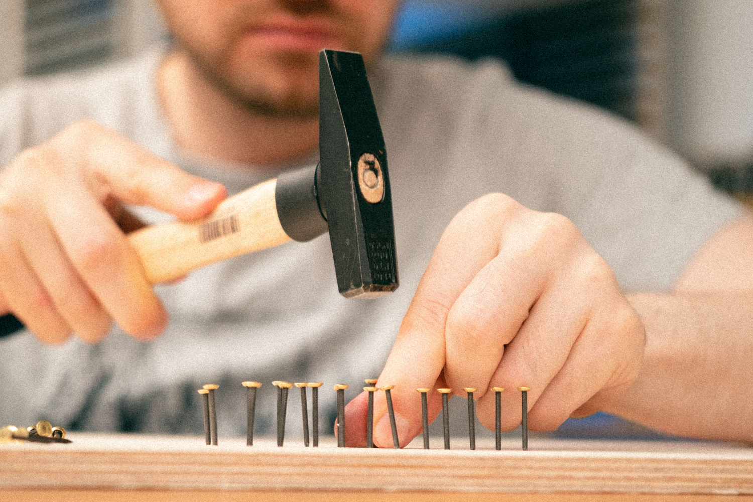 nails are being hammered into a wooden board to create a string art picture